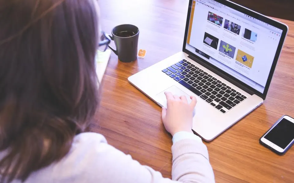 Profissional trabalhando no notebook com uma xícara de café ao lado
