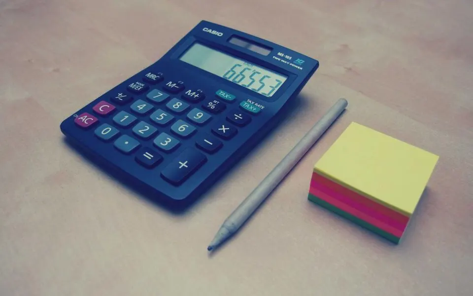 Calculadora e bloco de anotações sobre a mesa